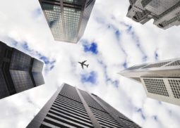Plane flying above multiple tall buildings
